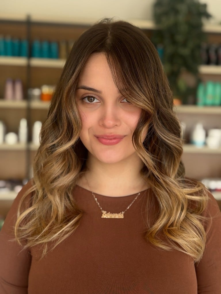 Morena iluminada com mechas douradas contornando o rosto
