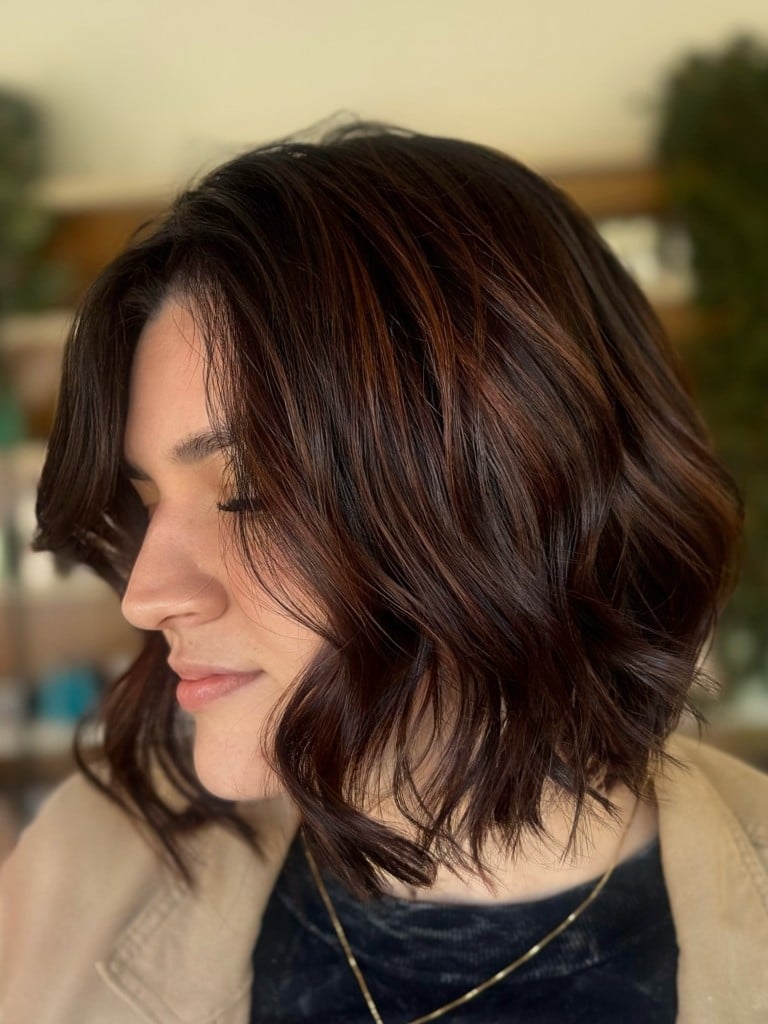 Corte bob com ondas e reflexos acobreados no castanho
